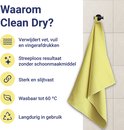 Gele Clean Dry doek hangend aan een haakje tegen een betegelde muur met voordelenlijst.