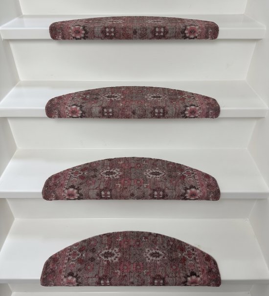 Halve maanvormige trapmatten met een roze en bruin oosters medaillonpatroon, geplaatst op witte treden.