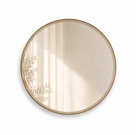 Ronde spiegel met een bronzen rand, 40 cm breed, met een facetrand. De weerspiegeling toont gordijnen met zonlicht.