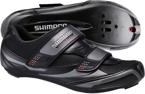 Zwarte Shimano fietsschoenen met klittenbandsluiting, mesh-details en glanzende accenten op een stijve zool.