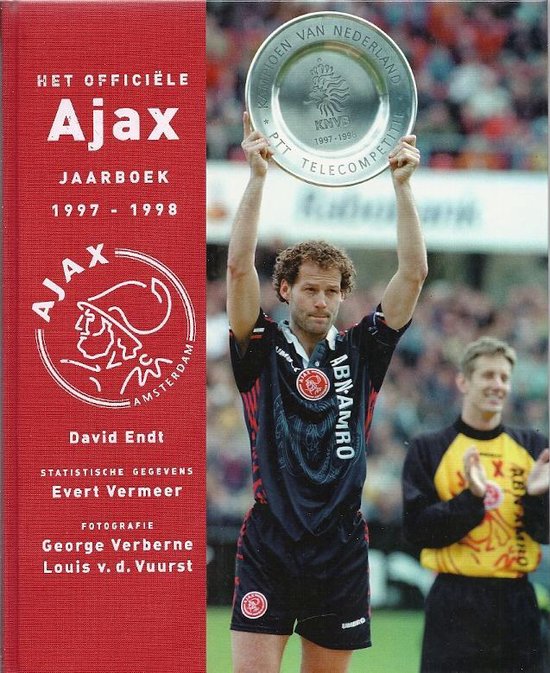 Voetballer met een zilveren beker, "KAMPIOEN VAN NEDERLAND 1997-1998" op de beker. Ajax shirt met "ABN AMRO".