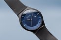 Zwart horloge met blauwe wijzerplaat, zilveren indexen en datum. De wijzerplaat heeft een subtiel kleurverloop van licht naar donker blauw. Milanese band.