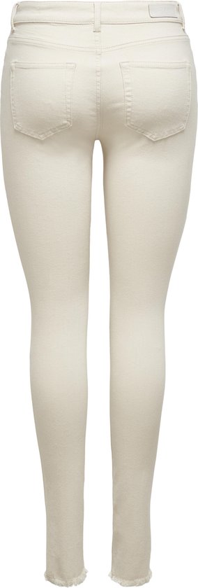 Achterkant van crème skinny jeans met rafels aan de onderkant.