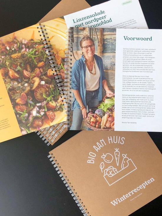 Een open kookboek met een salade en een vrouw met een mand vol groenten.