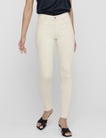Model met een navy top en beige skinny jeans met rafelige zoom.