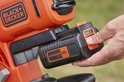 Hand die een 36V 2.5Ah lithiumbatterij in een oranje BLACK+DECKER bladblazer schuift.