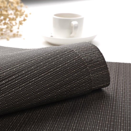 Antracietkleurige placemat van geweven materiaal, deels opgerold.