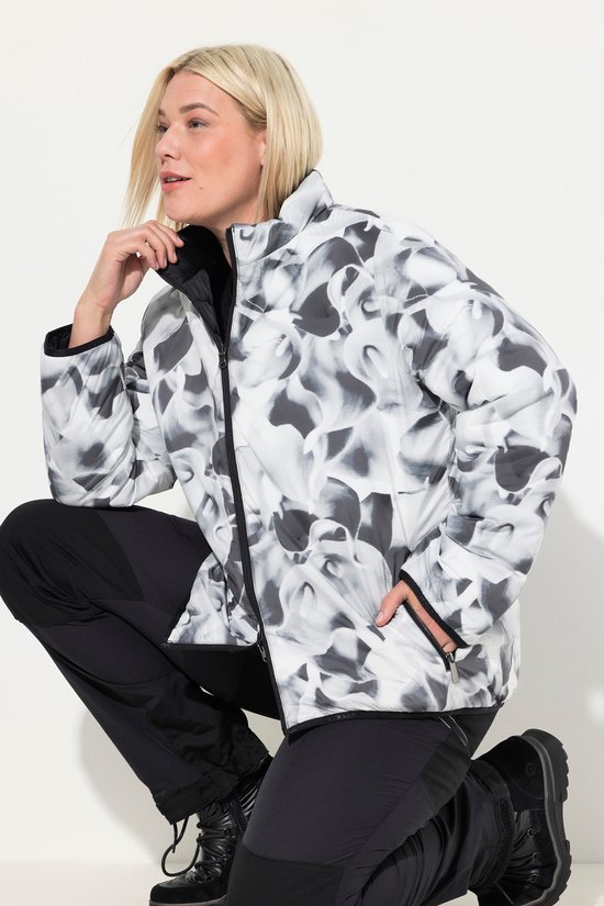 Model draagt een omkeerbaar HYPRAR jack in zwart-wit abstracte print, met zwarte rits en boorden.
