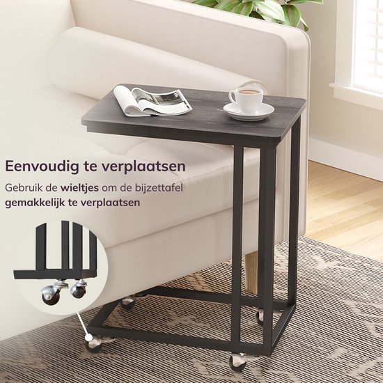 Zwart bijzettafeltje op wieltjes, makkelijk te verplaatsen naast een bank.
