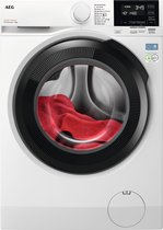 Witte AEG wasmachine met zwarte rand rond de trommel en rode handdoek erin.