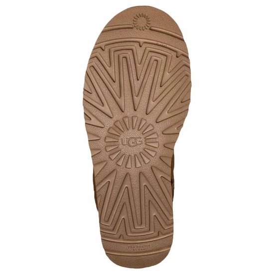 Onderkant van een cognackleurige UGG laars met een UGG logo in het midden.