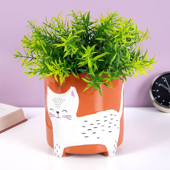 Oranje keramieken bloempot met een wit kattenmotief, gevuld met een groene kunstplant.