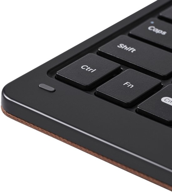 Detail van een zwart toetsenbord met 'Ctrl', 'Fn' en 'Shift' toetsen, aan de rand van een bruine hoes.