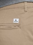 Detail van een beige chino broek met een "Jack & Jones" label op de achterzak.