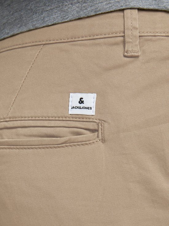 Detail van een beige chino broek met een "Jack & Jones" label op de achterzak.