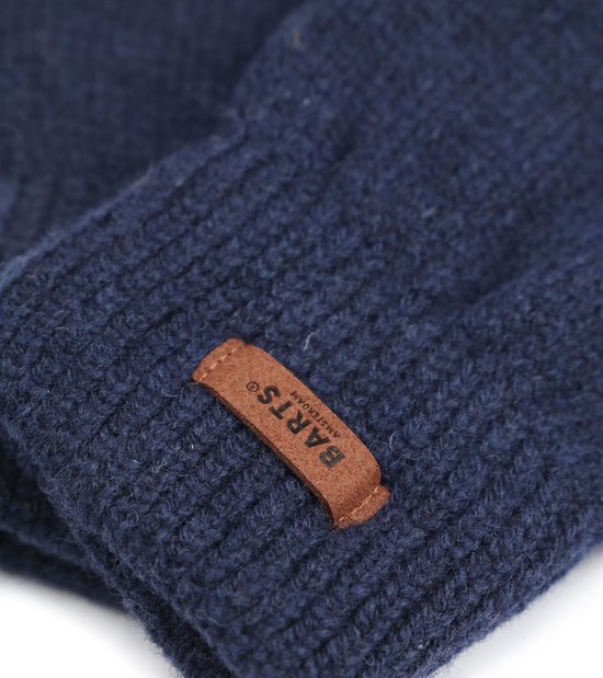 Close-up van donkerblauwe gebreide stof met een bruin leren Barts Amsterdam label.