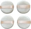 Quatre éponges rondes en coton blanc avec un ruban en satin rose.