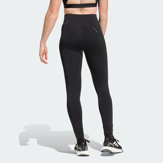 Achterkant van een zwarte Adidas legging met subtiel patroon op de enkel.
