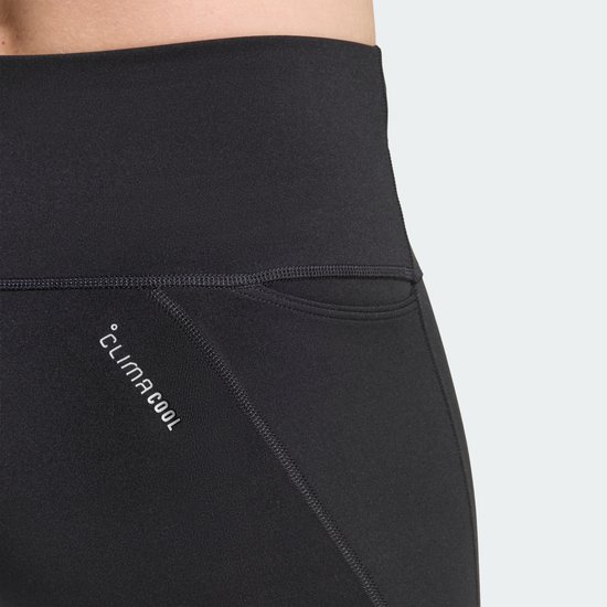 Close-up van zwarte Adidas legging met 'Climacool' logo en een klein zakje.