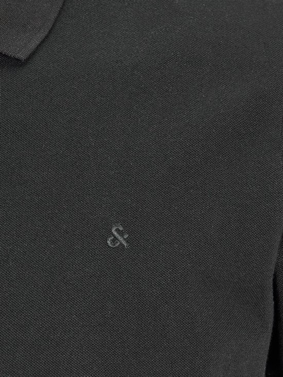 Close-up van een zwarte polo met geborduurd logo op de borst