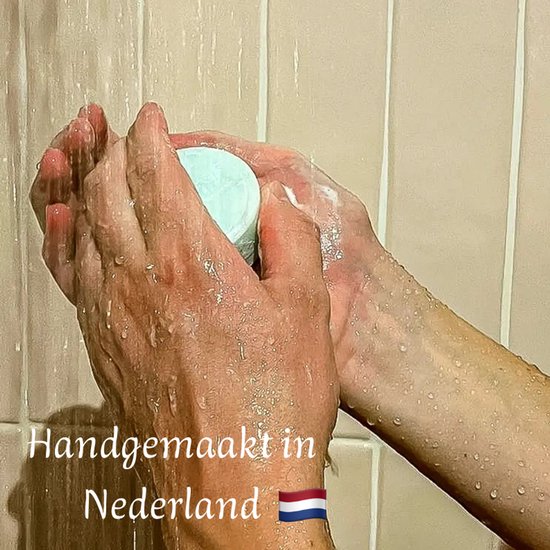 Twee handen wassen zich met een mintgroen zeepje onder de douche. Natte handen en zeep. Tekst: Handgemaakt in Nederland met Nederlandse vlag.