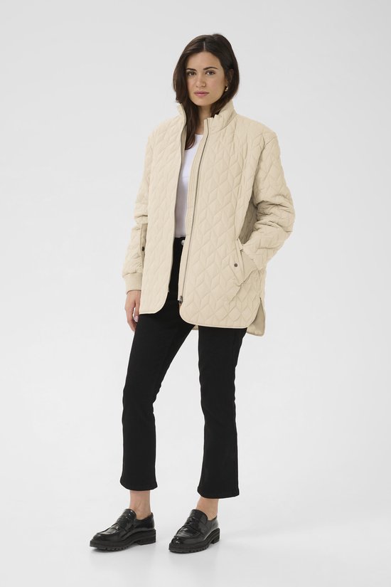 Model draagt een beige gewatteerde jas met ruitpatroon, staande kraag en rits.