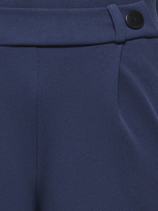 Sluiting van een marineblauwe wijde broek met één knoop.