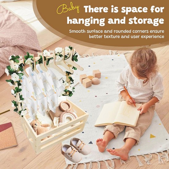 Baby speelt met houten speelgoed naast een babymand met kleding en knuffels.