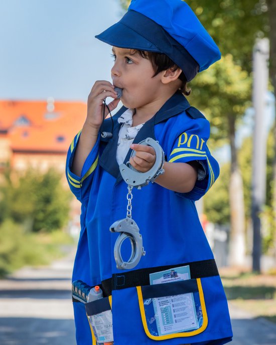 Jongen in blauw politie kostuum met handboeien en fluitje, speelt met een STOP-bord.