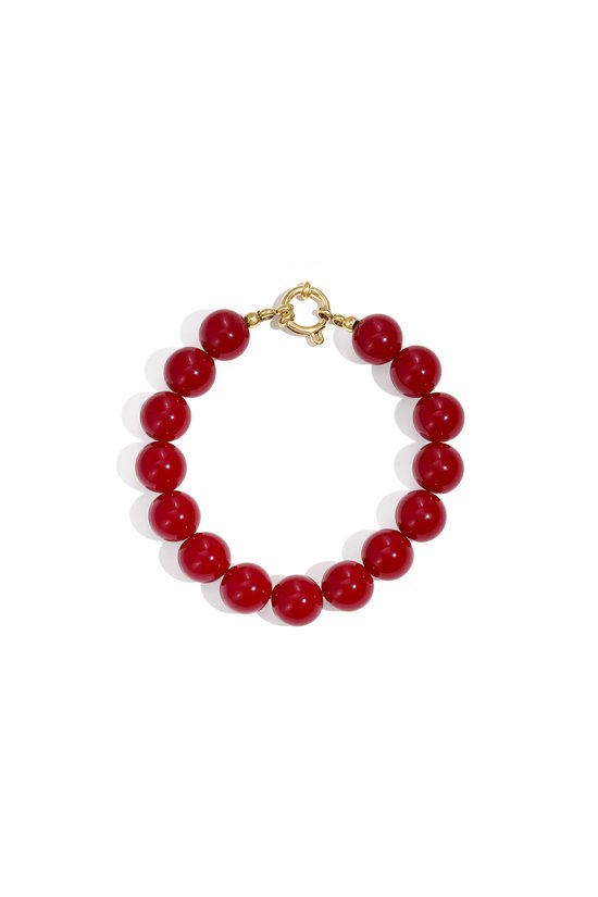 Bracelet rouge avec de grosses perles rondes et une fermeture à maillons dorée.
