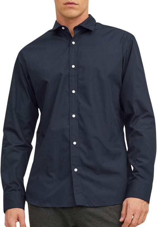 Homme portant une chemise bleu marine à manches longues et boutons blancs.