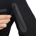 Close-up van een ritsvak op de mouw van een zwarte Nike Tech Fleece hoodie.