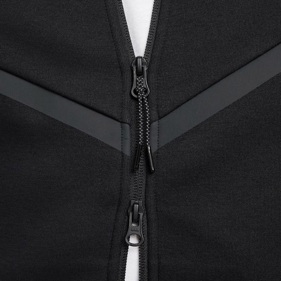 Close-up van de ritssluiting met trekkoord van een zwarte Nike Tech Fleece hoodie.