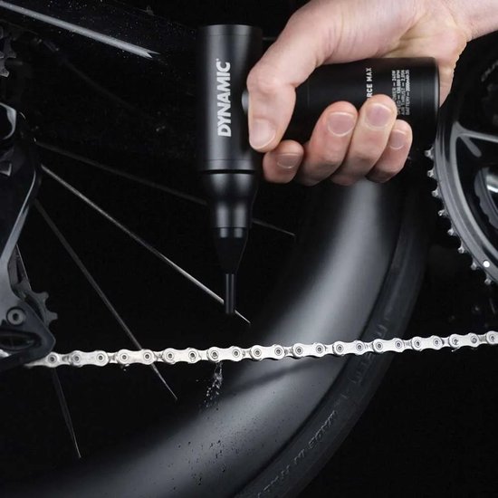 Een hand gebruikt de zwarte 'Airforce Max' blower om een fietsketting droog te blazen.