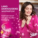 Femme appréciant le parfum de l'adoucissant Silan, avec des fleurs et le texte 'Parfum de linge longue durée'.