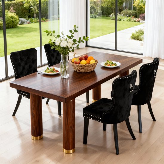 Een set van vier zwarte fluwelen eetkamerstoelen met ringen en spijkers rond een houten tafel met stoelen.