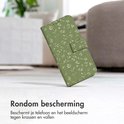 Groen telefoonhoesje met bladerpatroon op een vloer, leunend.