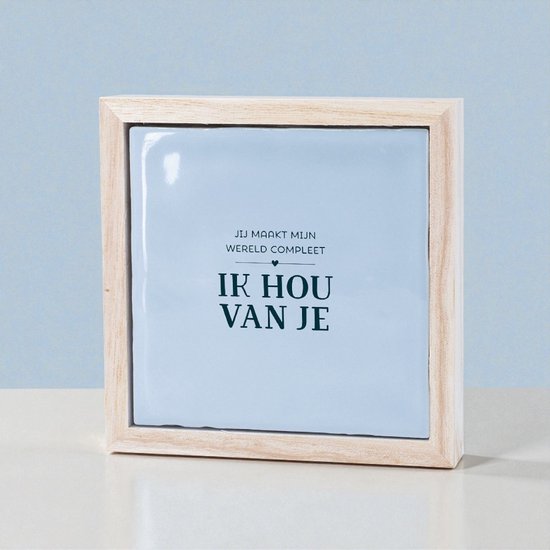 Lichtblauw tegeltje in een houten lijst met de tekst 'JIJ MAAKT MIJN WERELD COMPLEET' en 'IK HOU VAN JE'.