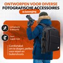 Man in de sneeuw met zwarte rugzak met oranje binnenkant en statief, de rugzak is lichtgewicht, ademend en comfortabel.