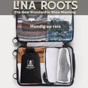 Une valise ouverte avec des vêtements et deux sacs de lavage Lina Roots à l'intérieur, dont un avec des chaussures.
