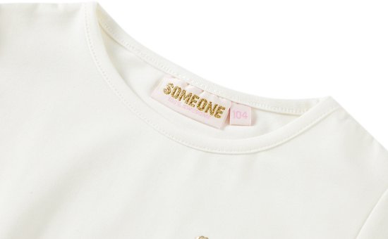 Crèmekleurig label van het merk 'Someone' met maat '104'.