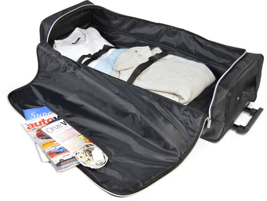 Zwarte reistas open met kleding, tijdschriften en lader.