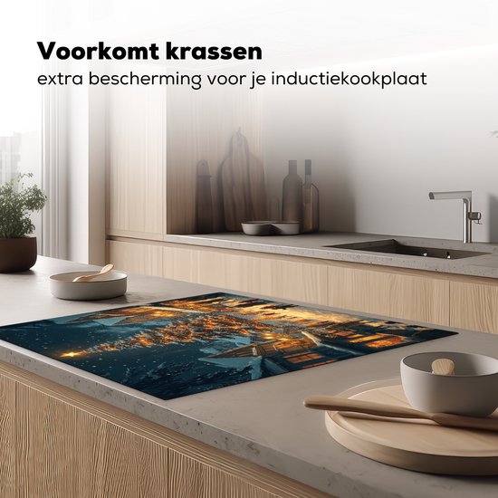 Inductiebeschermer met kerstdorp-print op een kookplaat, beschermt tegen krassen.