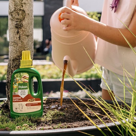 Een groene Pokon fles naast een boom, een persoon giet planten met een waterkan.