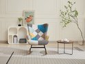 Fauteuil met patchwork design in diverse kleuren, in een woonkamer met modern meubilair.