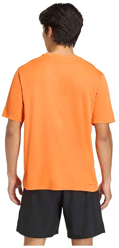 Oranje Adidas sport T-shirt met korte mouwen, gedragen door een man die terugkijkt.