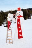 Model op een ladder met felrode panty, naast een grote sneeuwpop met FALKE sjaal.