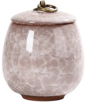 Lichtroze keramische mini-urn met gesloten deksel, textuur en gouden handvat, op een witte achtergrond.