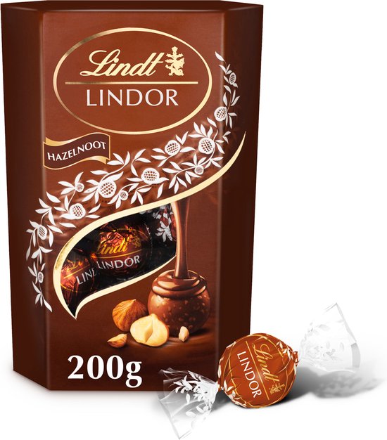 Doos Lindt LINDOR Hazelnoot melkchocolade bonbons, 200g, met een hazelnoot en een losse bonbon.