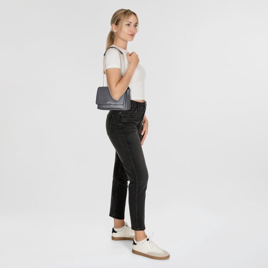Une femme porte un sac bandoulière Liu Jo anthracite.